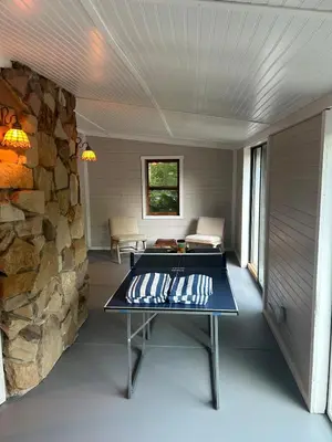 a room with a table and a stone wall at The Billy Lodge in Lucas