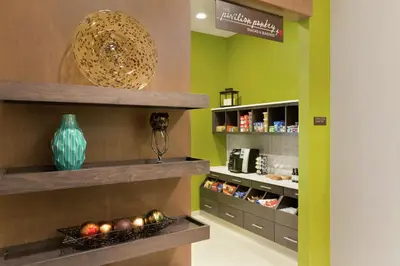 a store with green walls and shelves with food at Hilton Garden Inn Pittsburgh Airport South-Robinson Mall in Robinson Township
