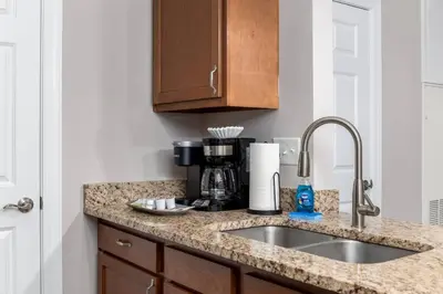 a kitchen counter with a sink and a coffee maker at The Pondview Penthouse King Bed Balcony WD in Westerville