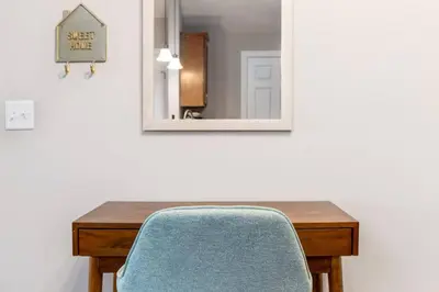 a table with a blue chair and a mirror at The Pondview Penthouse King Bed Balcony WD in Westerville