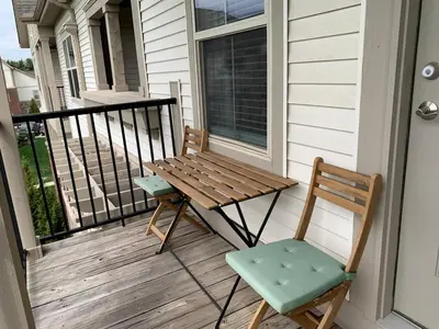 a wooden table and a chair on a porch at The Pondview Penthouse King Bed Balcony WD in Westerville