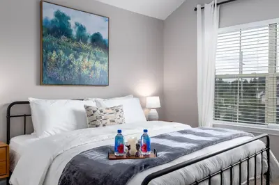 a bedroom with a bed with a tray of drinks on it at The Pondview Penthouse King Bed Balcony WD in Westerville