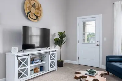 a living room with a tv on a white entertainment center at The Pondview Penthouse King Bed Balcony WD in Westerville