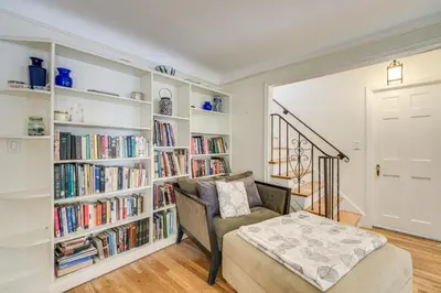 a living room with a chair and bookshelves at Historic University Heights Home with Private Yard! in University Heights