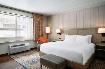 a hotel room with a large bed and a chair at Oglebay Resort in Wheeling