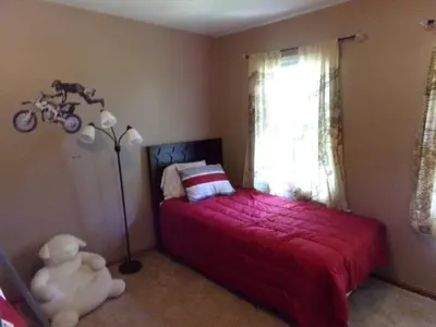 a bedroom with a red bed with a teddy bear next to a window at Family Friendly lodge located in the Hocking Hills in Rockbridge
