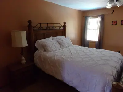 a bedroom with a bed with white sheets and a window at Family Friendly lodge located in the Hocking Hills in Rockbridge