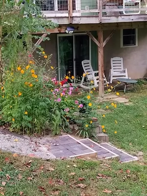 a porch with chairs and flowers in the yard at Country suite with bath and laundry in Athens