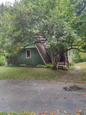 a green house with a tree in front of it at Country suite with bath and laundry in Athens