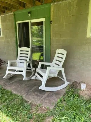 two white chairs sitting on the porch of a house at Country suite with bath and laundry in Athens