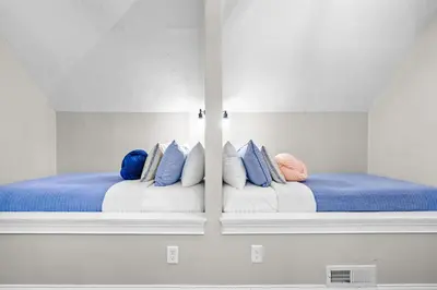 a room with two beds with blue and white pillows at Cedar Point, Kalahari, Sports Force, Hot tub, Fire pit, EV, Pets, Beach, Fireplace, Park in Huron