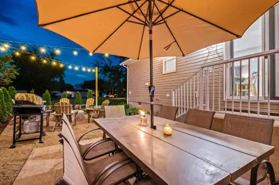 a wooden table with an umbrella on a patio at Cedar Point, Kalahari, Sports Force, Hot tub, Fire pit, EV, Pets, Beach, Fireplace, Park in Huron