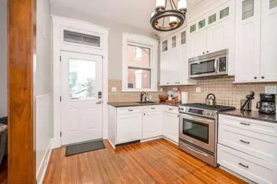 a kitchen with white cabinets and a stove top oven at Doctors Retreat with Hot Tub in Dayton