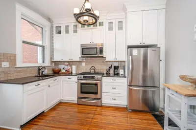 a kitchen with white cabinets and stainless steel appliances at Doctors Retreat with Hot Tub in Dayton