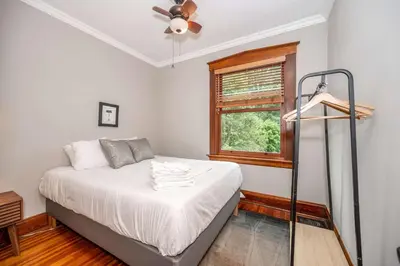 a bedroom with a bed with a ceiling fan and a window at Doctors Retreat with Hot Tub in Dayton