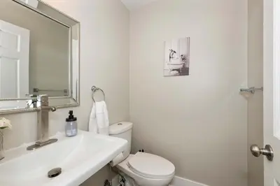 a bathroom with a sink and a toilet and a mirror at Cincy Comfort Retreat in Cincinnati