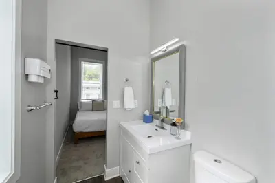 a white bathroom with a sink and a mirror at Cincy Comfort Retreat in Cincinnati