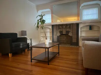 a living room with a table and a fireplace at Super close to Cleveland Clinic Fairview Colibri in Cleveland