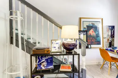 a staircase with a table with a lamp on it at 7 Mi to Dtwn Charming Couples Cove in Cincinnati in Cincinnati