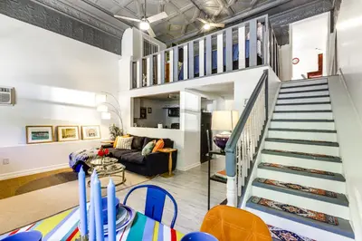 a living room with a staircase leading up to a loft at 7 Mi to Dtwn Charming Couples Cove in Cincinnati in Cincinnati