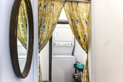 a laundry room with a mirror and a washer and dryer at 7 Mi to Dtwn Charming Couples Cove in Cincinnati in Cincinnati