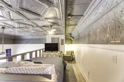 a bedroom with a bed and a tv on the ceiling at 7 Mi to Dtwn Charming Couples Cove in Cincinnati in Cincinnati