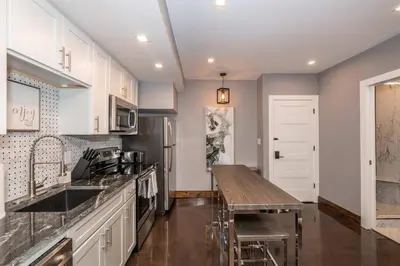 a kitchen with white cabinets and a wooden counter top at Luxury Mt Adams Retreat Apt 1 in Cincinnati