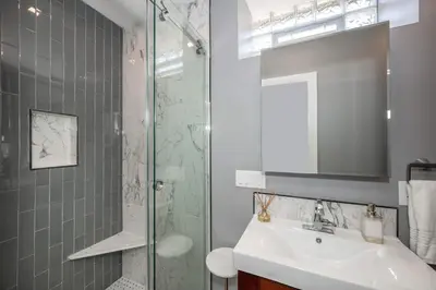 a bathroom with a sink and a glass shower at Luxury Mt Adams Retreat Apt 1 in Cincinnati