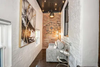 a hallway with a chair and a clock on the wall at Luxury Mt Adams Retreat Apt 1 in Cincinnati