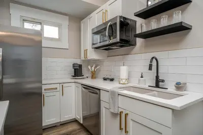 a white kitchen with a sink and a refrigerator at Lee Street Lodge - Minutes from DT in Covington