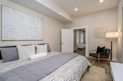 a bedroom with a large bed and a chair at Lee Street Lodge - Minutes from DT in Covington