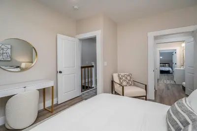 a bedroom with a bed and a mirror and a chair at Lee Street Lodge - Minutes from DT in Covington