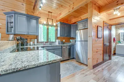 a kitchen with blue cabinets and a stainless steel refrigerator at 15 Mi to Hocking Hills Secluded Cabin with Hot Tub in Logan