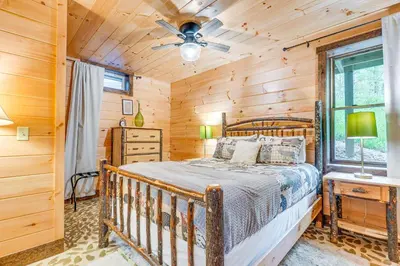 a bedroom with a bed and a ceiling fan at 15 Mi to Hocking Hills Secluded Cabin with Hot Tub in Logan