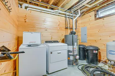 a kitchen with a washer and dryer in a cabin at 15 Mi to Hocking Hills Secluded Cabin with Hot Tub in Logan