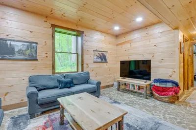 a living room with a couch and a tv at 15 Mi to Hocking Hills Secluded Cabin with Hot Tub in Logan