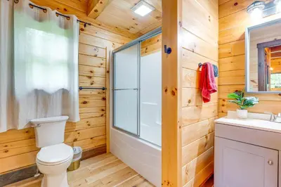 a bathroom with a toilet and a shower and a sink at 15 Mi to Hocking Hills Secluded Cabin with Hot Tub in Logan