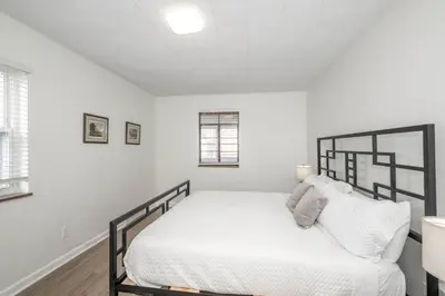 a white bedroom with a bed with white sheets at The Grand Elm Suites in Ludlow