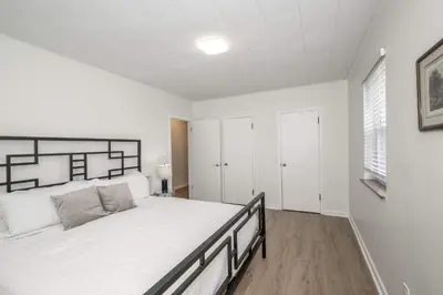 a white bedroom with a large bed in a room at The Grand Elm Suites in Ludlow