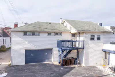 a white house with a garage and a house at The Grand Elm Suites in Ludlow