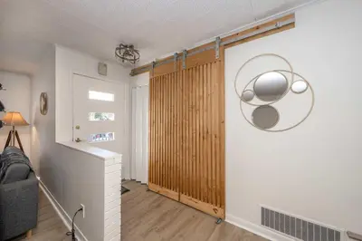 a living room with a wall with a wooden door at The Grand Elm Suites in Ludlow