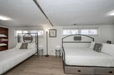 a bedroom with two beds and two windows at The Grand Elm Suites in Ludlow