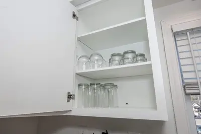 a kitchen cabinet filled with clear glass dishes at The Grand Elm Suite 2 in Ludlow
