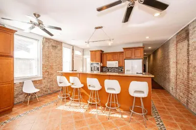 a kitchen with a bar with white stools at Sweet Escape in Cincinnati