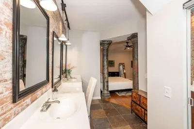 a bathroom with a sink and mirror and a bedroom at Sweet Escape in Cincinnati