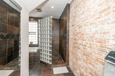 a bathroom with a brick wall and a shower at Sweet Escape in Cincinnati