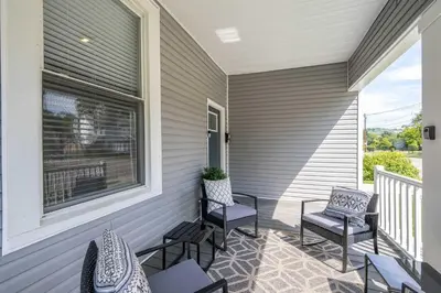a porch with chairs and a window on a house at Queen City Grand House in Cincinnati