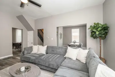 a living room with a gray couch and a table at Queen City Grand House in Cincinnati