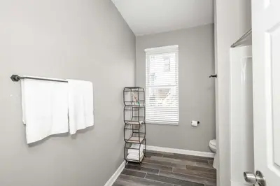 a bathroom with a toilet and a towel rack at Queen City Grand House in Cincinnati