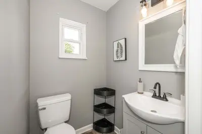 a bathroom with a white toilet and a sink at Queen City Grand House in Cincinnati